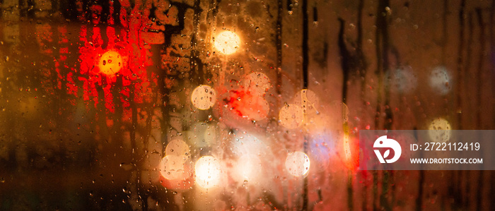 Bannière de lumières floues de la ville derrière une vitre de nuit sous la pluie