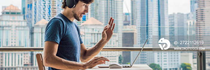 Young man teaches a foreign language or learns a foreign language on the Internet on her balcony against the backdrop of a big city. Online language school lifestyle BANNER, long format