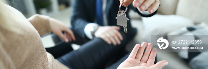 Close-up of client and realtor. Agent giving keys of apartment to new owner in disabled carriage after signed lease agreement. Real estate concept. Adaptation of people with disabilities in society