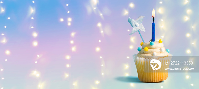 Celebratory cupcake with a decorative lit candle