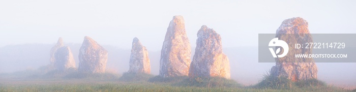 Menhir alignment view at Camaret sur mer in a morning fog at sunrise. Brittany, France. Golden light. Panoramic picturesque scenery. Travel destinations, national landmarks. sightseeing, history