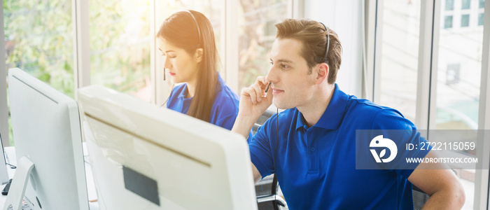 Customer support operator at work. Team Business and Delivery call center in office. Working with a headset in blue uniform.