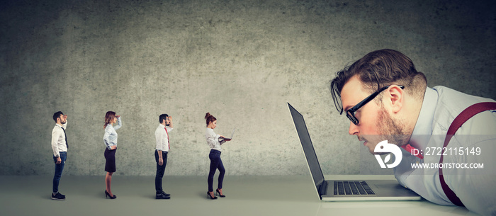 Curious businessman looking at laptop analyzing group of businesspeople applying online for a job