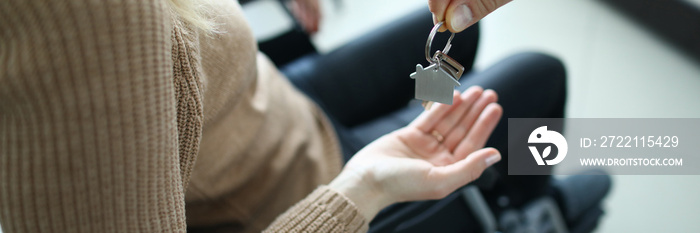 Woman is sitting in wheelchair and keys are handed over to her. Getting housing for disabled people concept