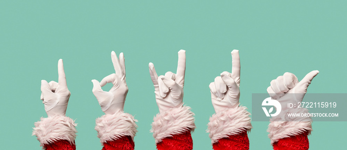 Five Santa’s hands in white gloves on blank blue background.