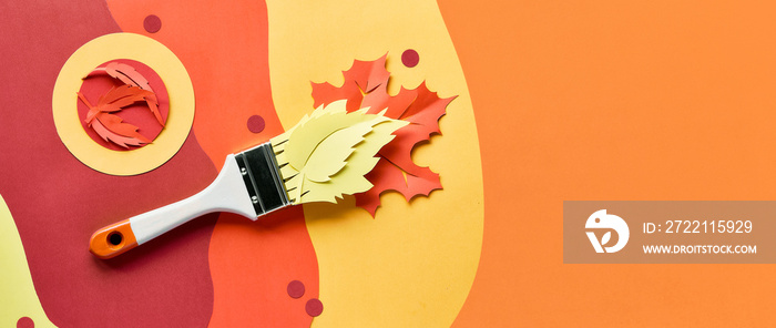 Brush loaded with paint made of paper Autumn leaves. Home renovation panoramic background, top view.