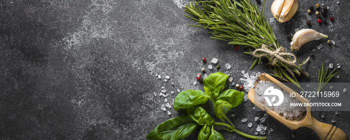 Spices and herbs over black stone table.