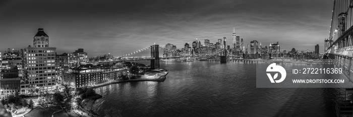 Brooklyn, Brooklyn park, Brooklyn Bridge, Janes Carousel and Lower Manhattan skyline at night seen from Manhattan bridge, New York city, USA. Black and white wide angle panoramic image.