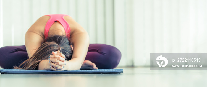 Young woman exercising stretching back yoga pose