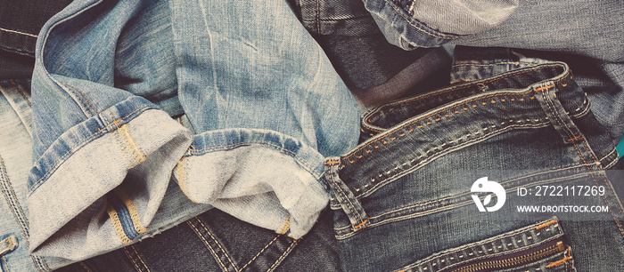 Jeans denim flat lay. Set of different jeans in a heap, denim background banner