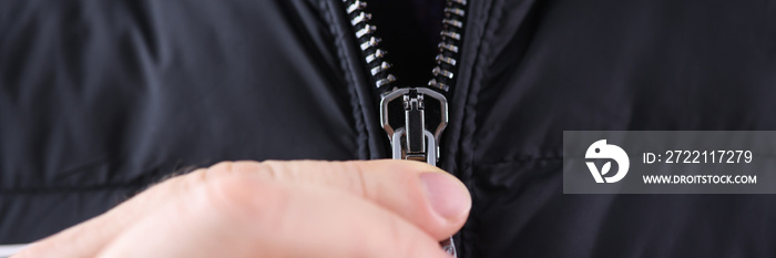 Male hand closing zipper on black jacket closeup. Custom tailoring concept