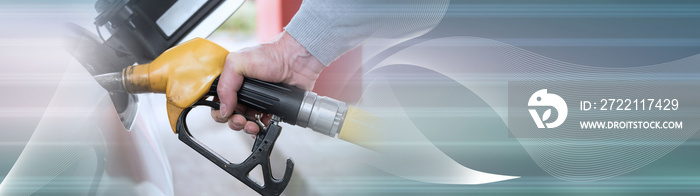 Hand holding fuel pump nozzle and refilling car; panoramic banner