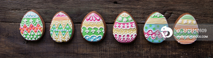 gingerbread cookie in the form of color easter eggs on dark wooden background.