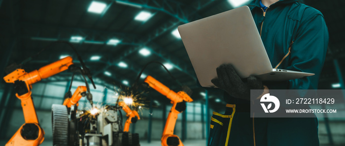 Engineer use advanced robotic software to control industry robot arm in factory . Automation manufacturing process controlled by specialist using IOT software connected to internet network .