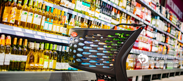 A shopping cart with grocery products in a supermarket