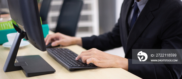 Hand of male employee typing on computer keyboard at desk in the office. working, typing work report. customer support service. web banner size