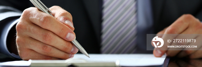 Male arm in suit and tie fill form clipped to pad