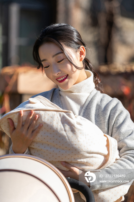 年轻的母亲抱着襁褓婴儿