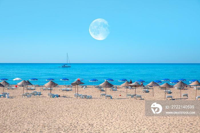 Holidaymakers sunbathing at Patara beach with full moon - Antalya, Turkey   Elements of this image furnished by NASA