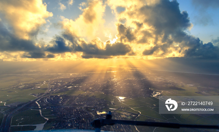 Sun rays shining through clouds above Amsterdam