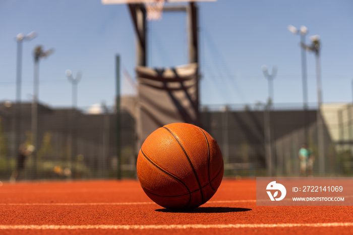 Top view orange ball for basketball lying on the rubber sport court. Sport red ground outdoor in the yard