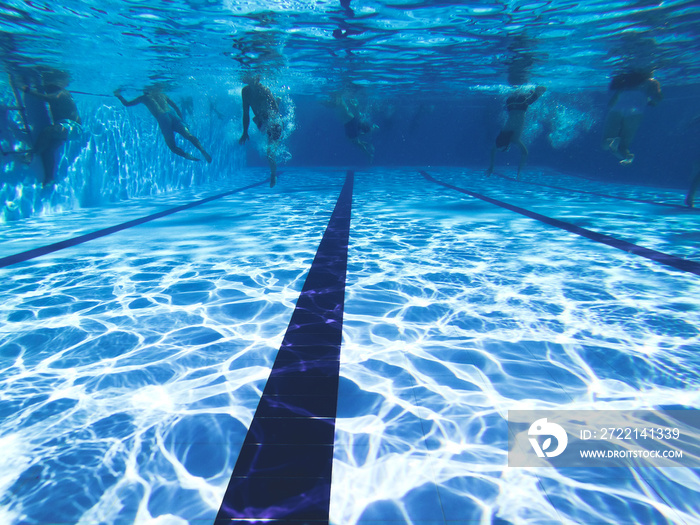 People diving in a swiming pool. Underwater view.