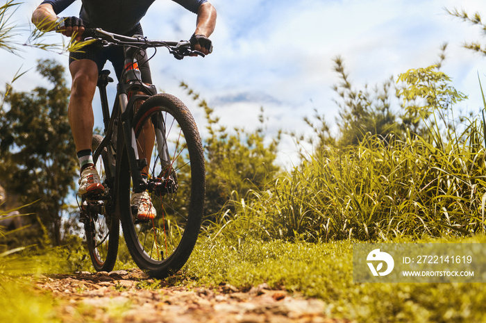 Mountain biking low angle view, Cyclist ride training on MTB track in forest with mountain bike, Outdoor sport activity fun and enjoy riding. Basic techniques training for safe on trail of athlete.