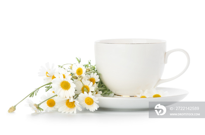 Cup of tasty chamomile tea with flowers on white background