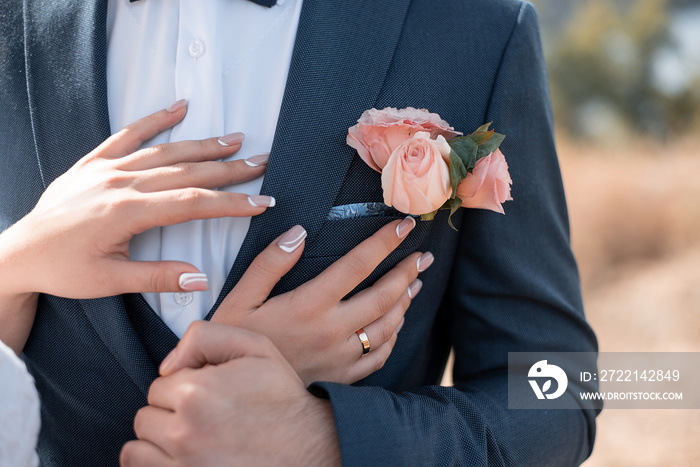 bride’s hands on the groom’s boutonnieres. flower wedding decor for event agencies