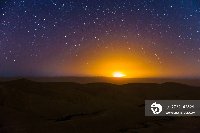 Night sky stars over desert hills sunset light.