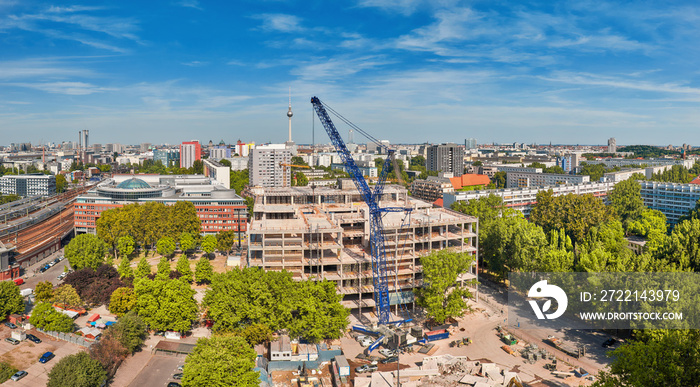 View from above on construction site with crane, television tower on Alexanderplatz and Berlin city skyline