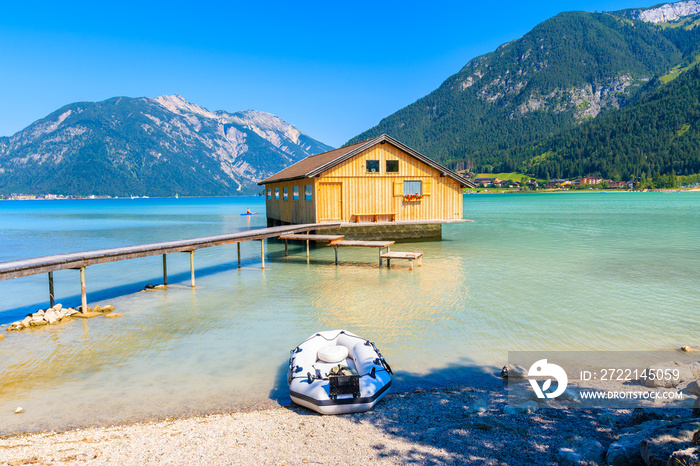 Wooden boat house and pier of shore of beautiful Achensee lake on sunny summer day, Tirol, Austria
