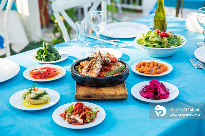 Shrimp, Seafoods, appetizers and salads on the table in Fish Restaurant. Beach Restaurant in Greece or Turkey. Aegean seaside, Greek or Turkish style fish restaurant in Bodrum, Santorini or Mykonos