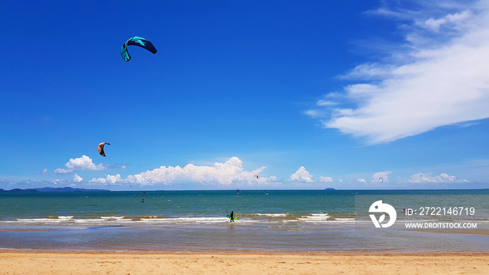 Many people playing kite, parasail or parachute on beach with sea or ocean , blue sky and cloud background with copy space. Activity and sport  concept