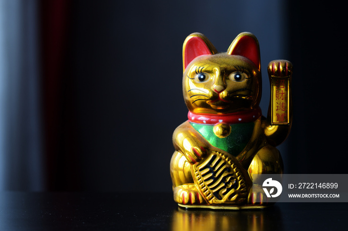 Golden Maneki Neko, the Lucky Cat, covered with dust. The concept of time and expectation of good luck