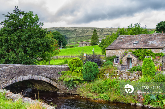 Old stone house by the river in Yorkshire Dales National Park, England, United Kingdom