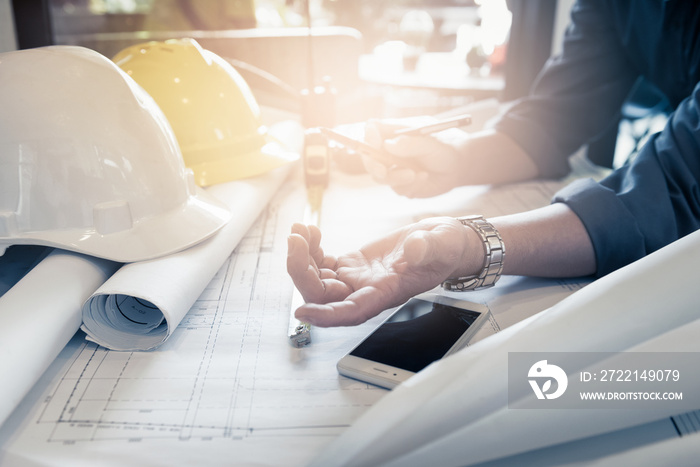 Close up hand of civil engineer people with drawing blueprint discussion in the office