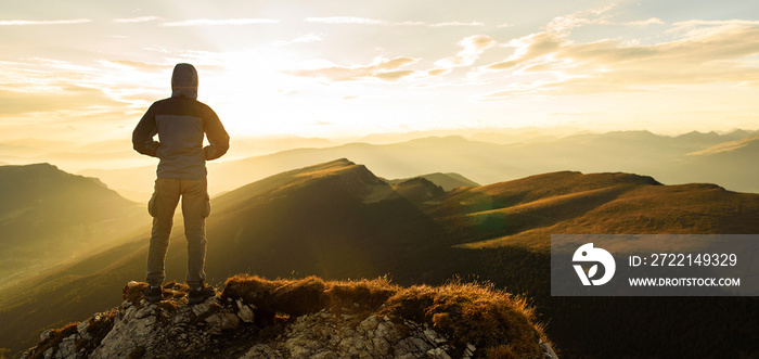 Silhouette of the man on top the peak of mountain on sunrise sky , Sport and active life onceptual design.