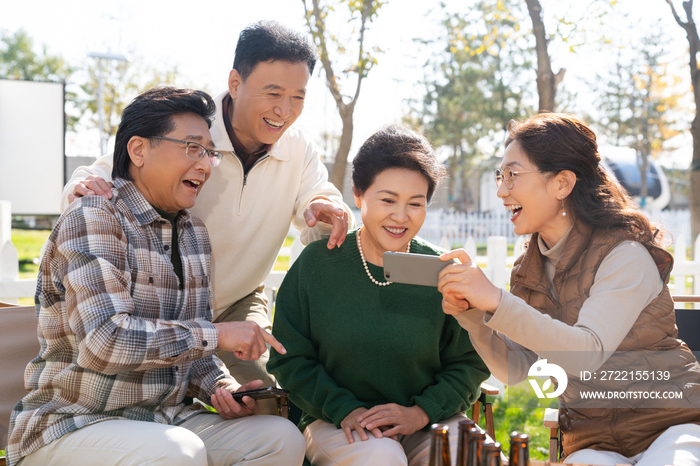 一群中老年人在房车露营地看手机视频