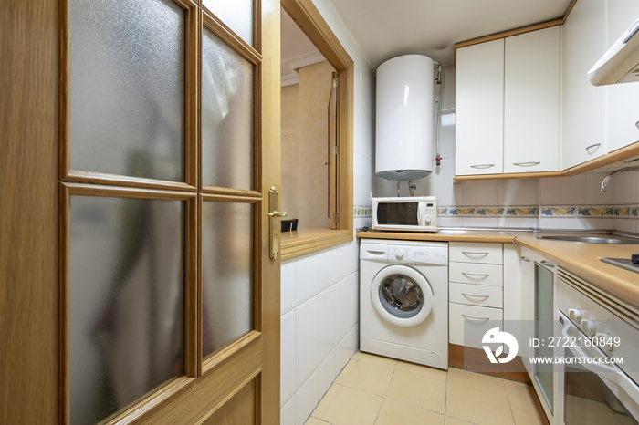 Corner kitchen with white furniture, hatch window to the living room, white appliances and electric 