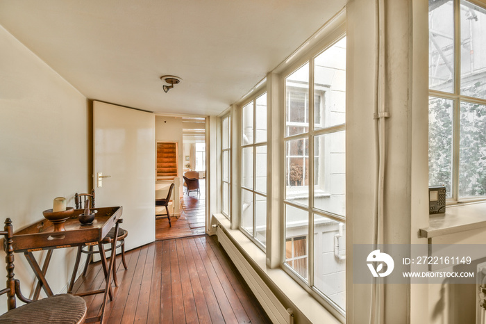 the inside of a house with wood flooring and large windows that look out onto the street in an urban