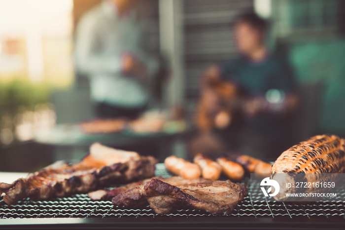 Close up grilled meats and various food on the grill and celebrations of friends who are playing gui