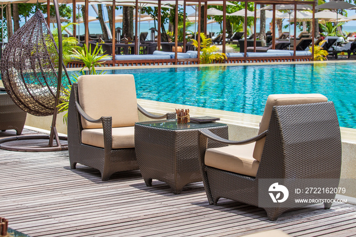 Rattan table and chairs on the terrace next to the tropical beach and the sea, Thailand