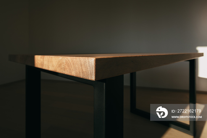 Detailed texture of modern wooden table and angular iron structures in form of legs on sides.Table i