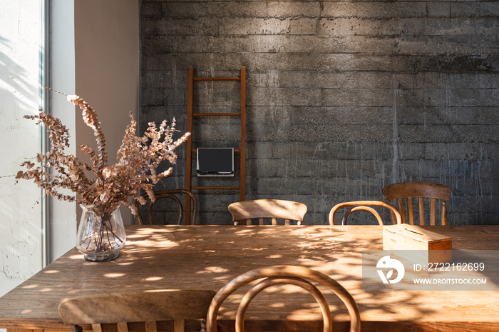 Interior of living room with wooden table, chair, dry leaf in glass wave, tissue box and wooden stai