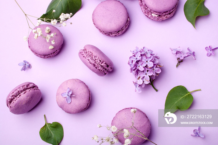 Lilac macarons and lilac flowers on a pastel lilac background. Delicious dessert. Flat lay style. Ho