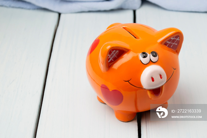 Piggy bank in the shape of a pig on a wooden background. Copy space.