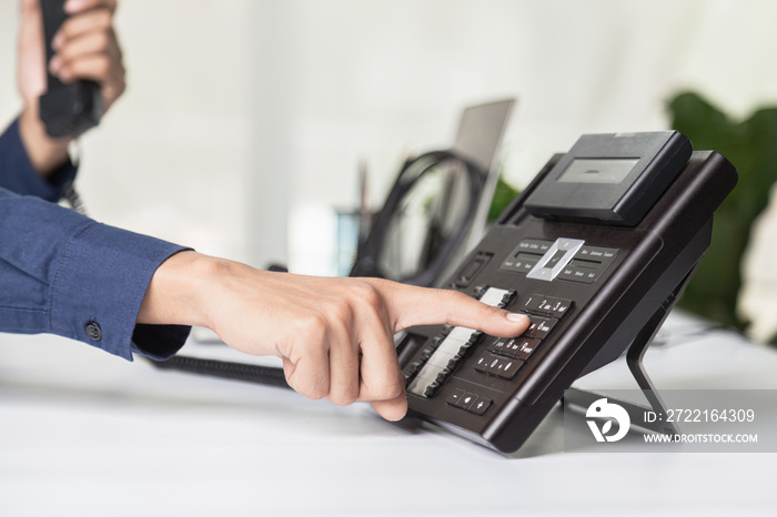 Call center staff man hand point to press the button number on the phone office desk , Communication