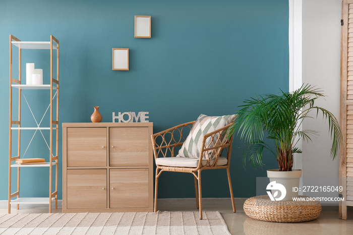 Interior of stylish living room with wooden drawers, shelving unit and armchair