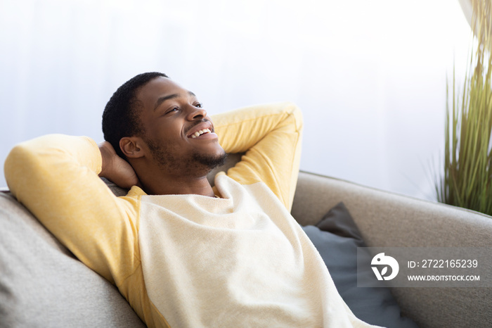 Closeup of black guy relaxing on couch at home